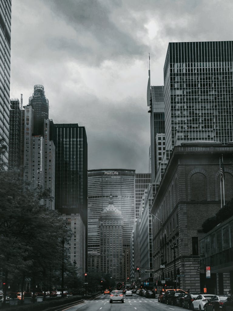 Monochrome cityscape depicting towering skyscrapers under an overcast sky, creating a dramatic urban scene.